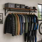 Clothes rail and wood shelf holding jackets and wetsuits below storage boxes and caps